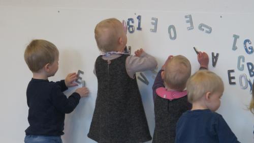 Dagplejebørn leger med bogstaver